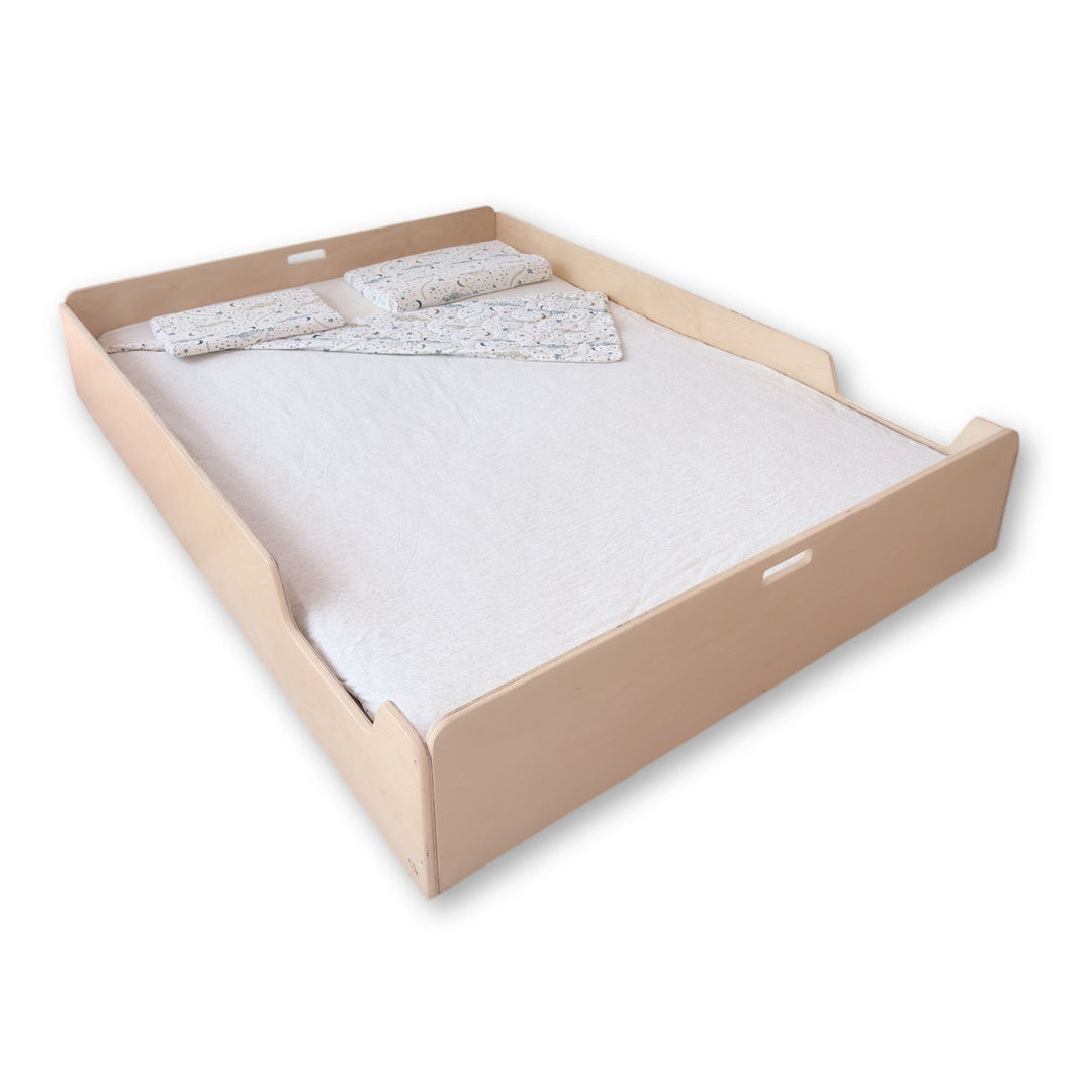 Beige bed frame with mattress and bedding on a white background