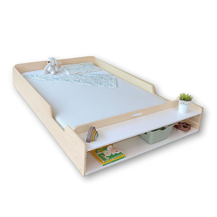 Children's bed with storage drawers and toys on a white background