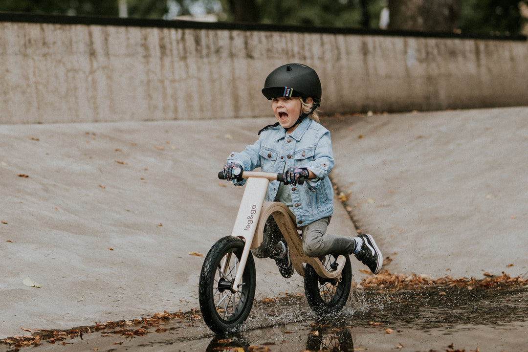 kid riding a wooden balance bike