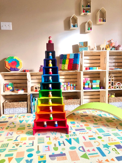 Colorful toy shelf in a playroom with various toys and wooden crates.