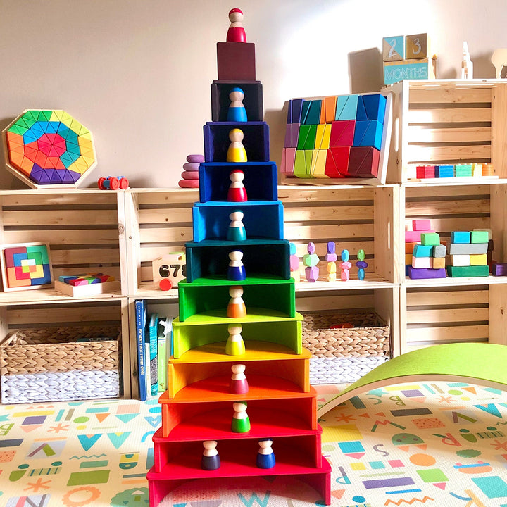 Colorful toy pyramid with wooden blocks and educational toys in a playroom setting.