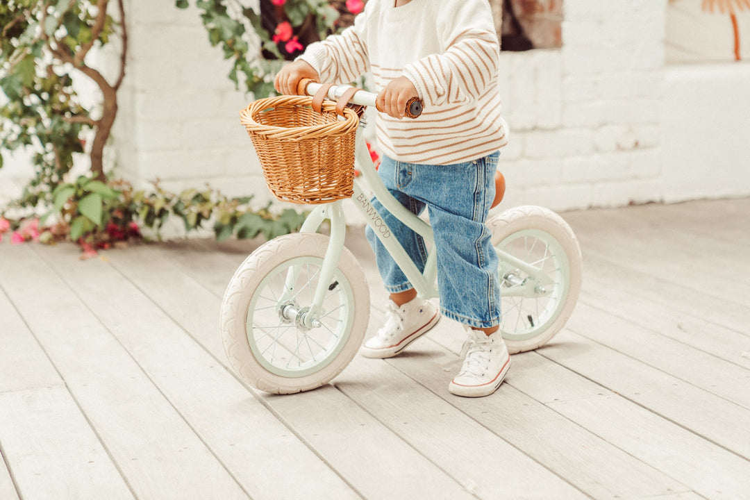 Toddler pushing along on the Banwood First Go balance bike outdoors