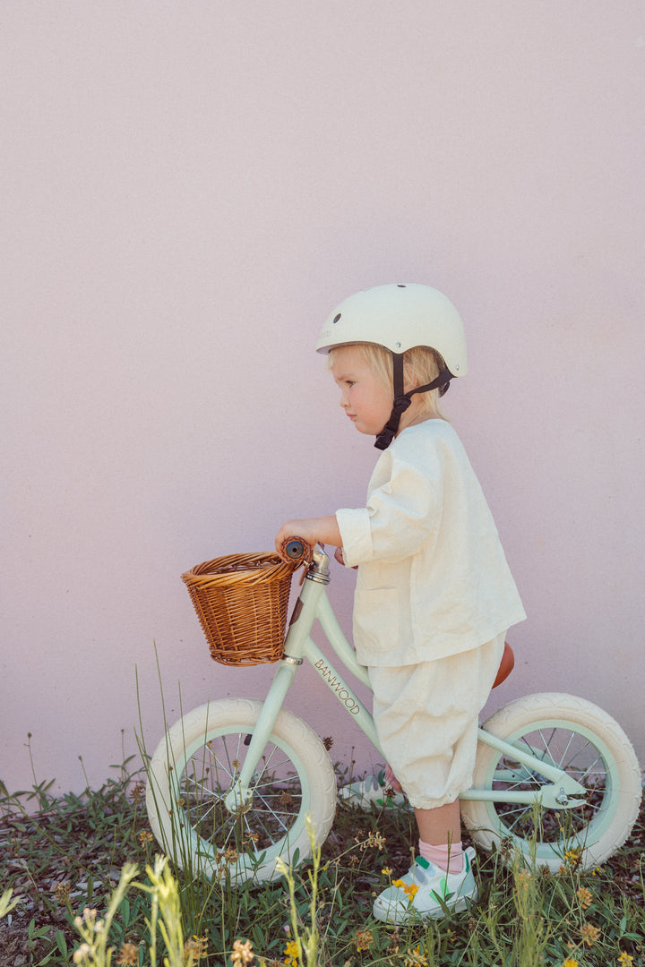 Child in a helmet gliding on the Banwood First Go balance bike