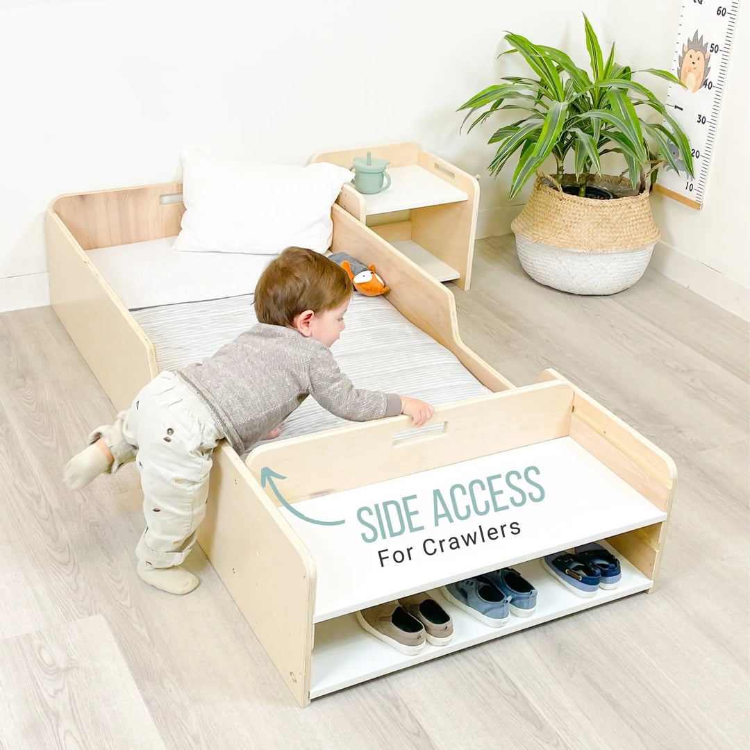 Child playing on a wooden floor bed with side access feature, shoes underneath, plant and height chart in the background.
