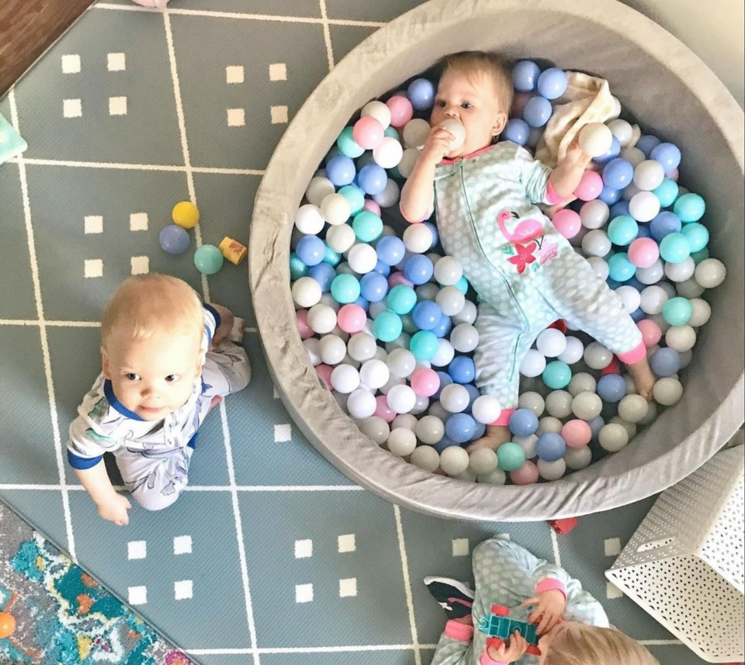 Two Kids Playing In A Ball Pit