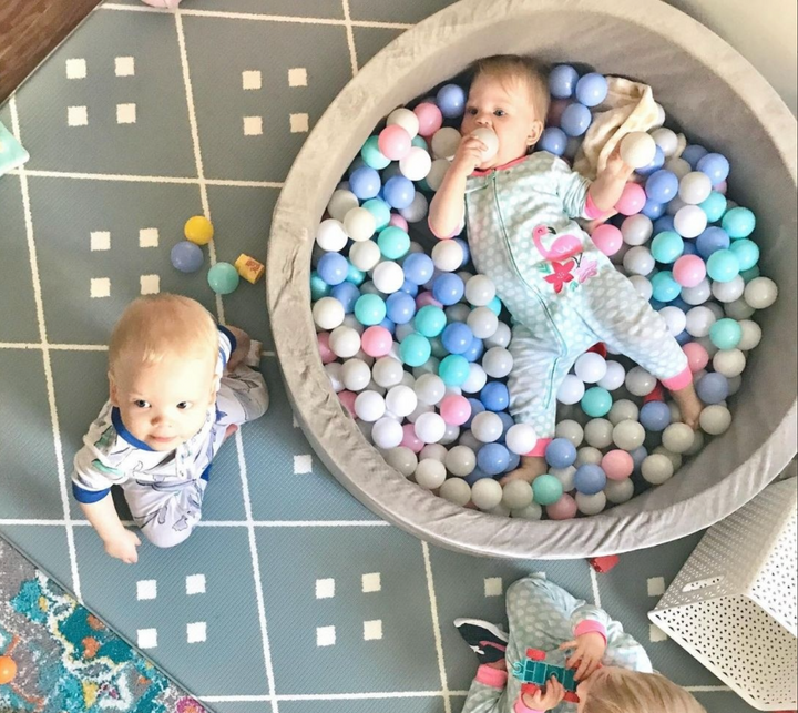 Two Babies Playing In A Ball Pit
