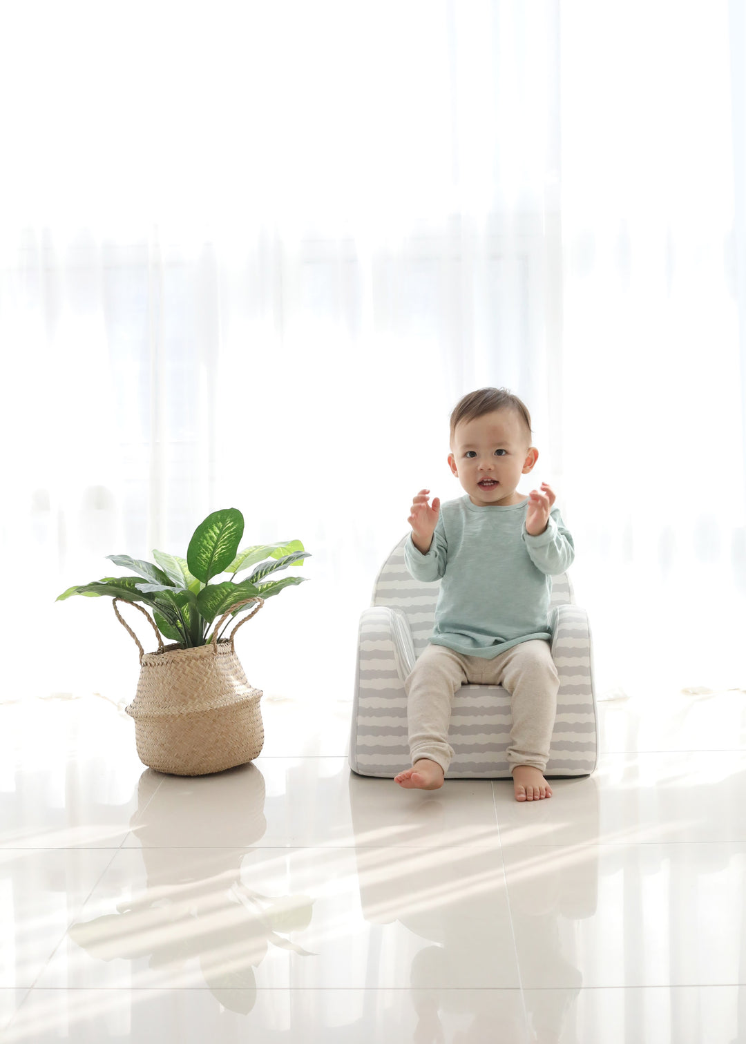 Baby sitting on the Baby Care Grey with Stripe kids sofa