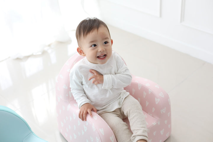Baby smiling on the Baby Care Pink with Hearts kids sofa