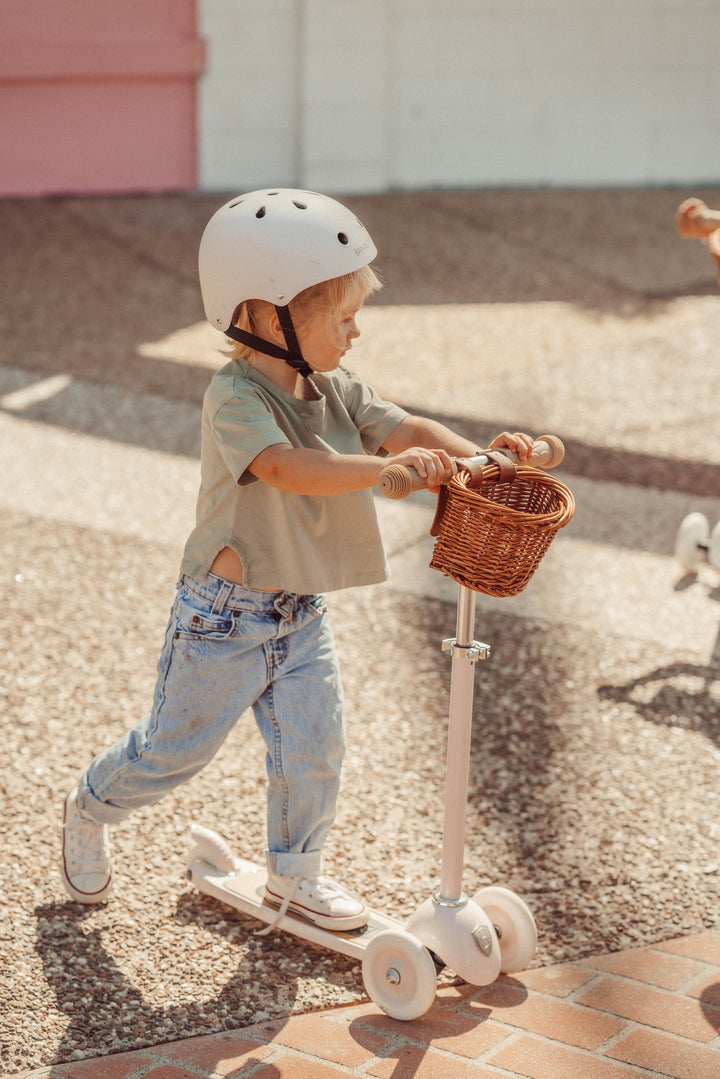 Child in a helmet riding the Banwood Vintage Scooter