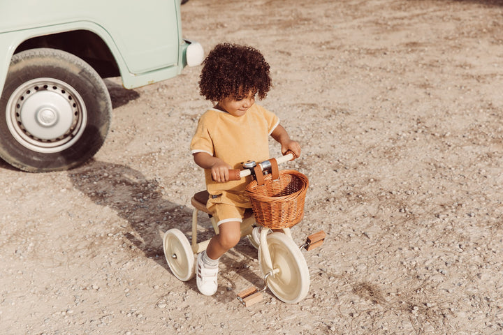 Child pedalling the Banwood Vintage Trike on a camping trip
