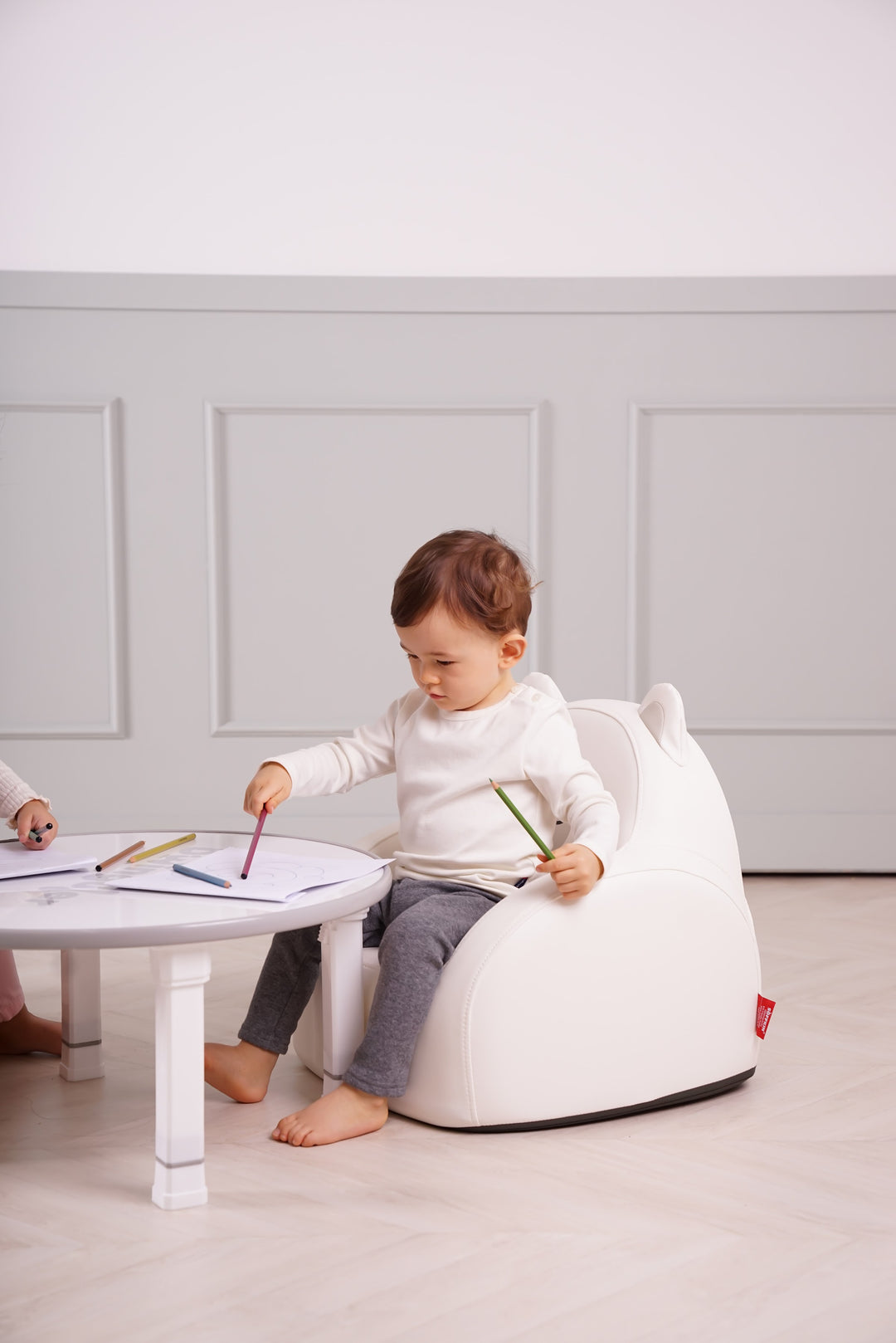 Child drawing while sitting on the Dwinguler Polar Bear kids sofa