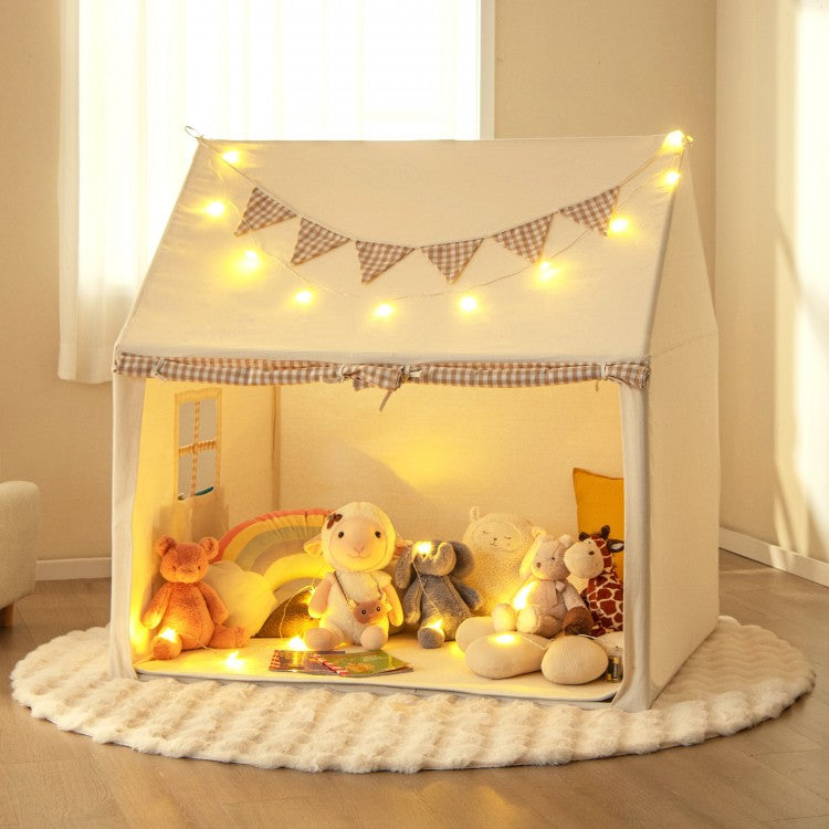 Children's play tent with toys and string lights in a room.