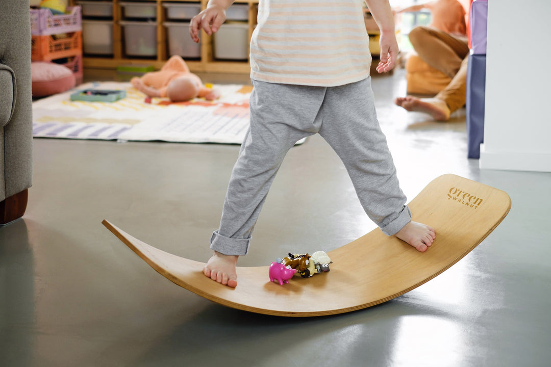 Kid Playing With A Wooden Wobble Balance Board